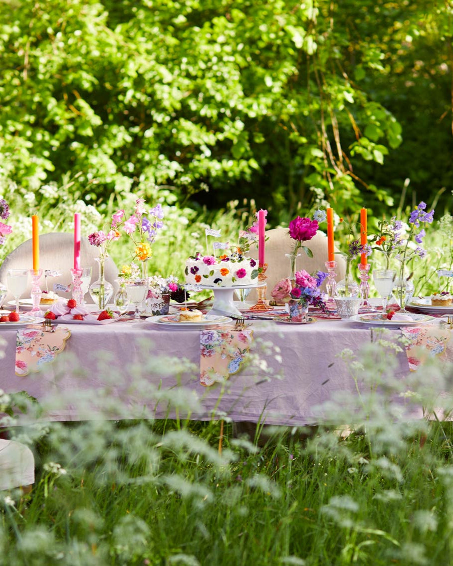Decorated outdoor table with flowers and candles in a natural setting