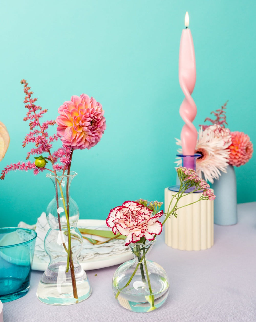 Trio of Bud Vases filled with pink floral stems in colourful modern table set up